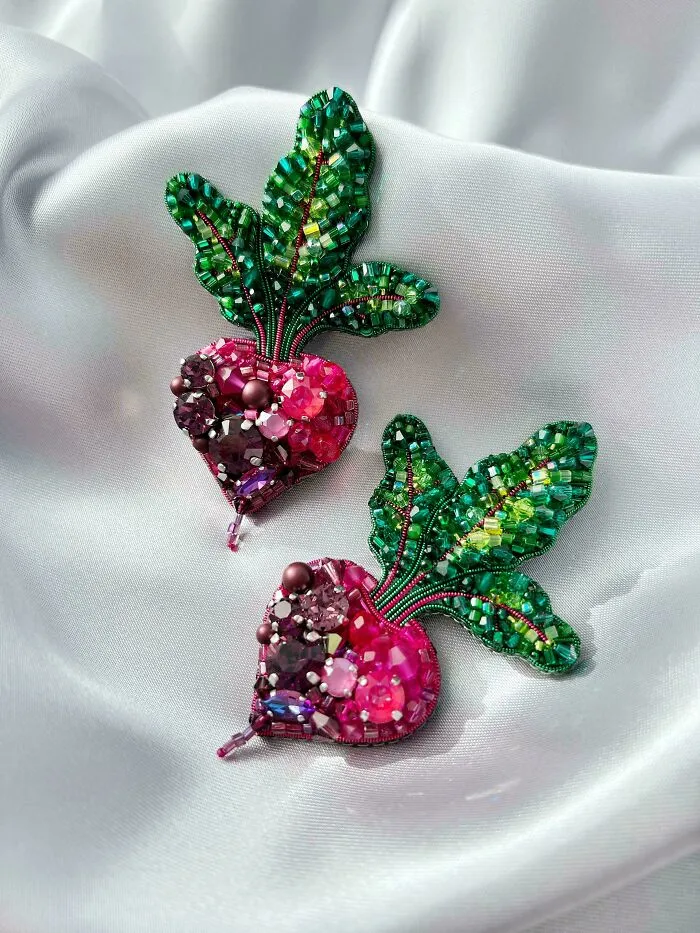 Embroidered radish designs embellished with colorful beads and sequins showcasing incredible embroidery skills on white fabric.