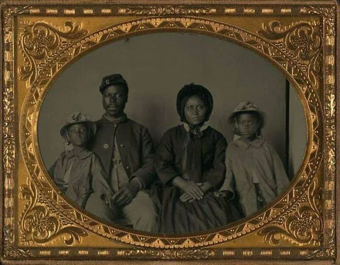 Victorian Era family portrait in an ornate frame, showcasing period clothing and style.
