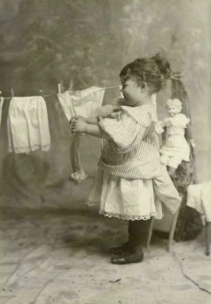 Margery Bish colgando ropa de muñecas en un tendedero, 1895. Foto tomada por su padre.