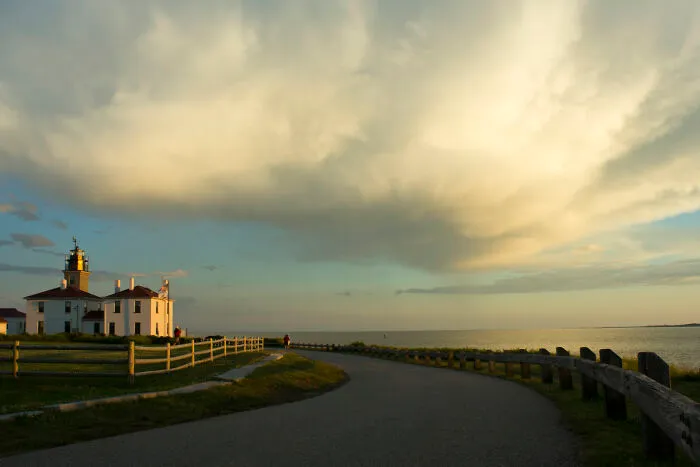 Lighthouse by the ocean with a dramatic sky, showcasing amazing views in coastal states.
