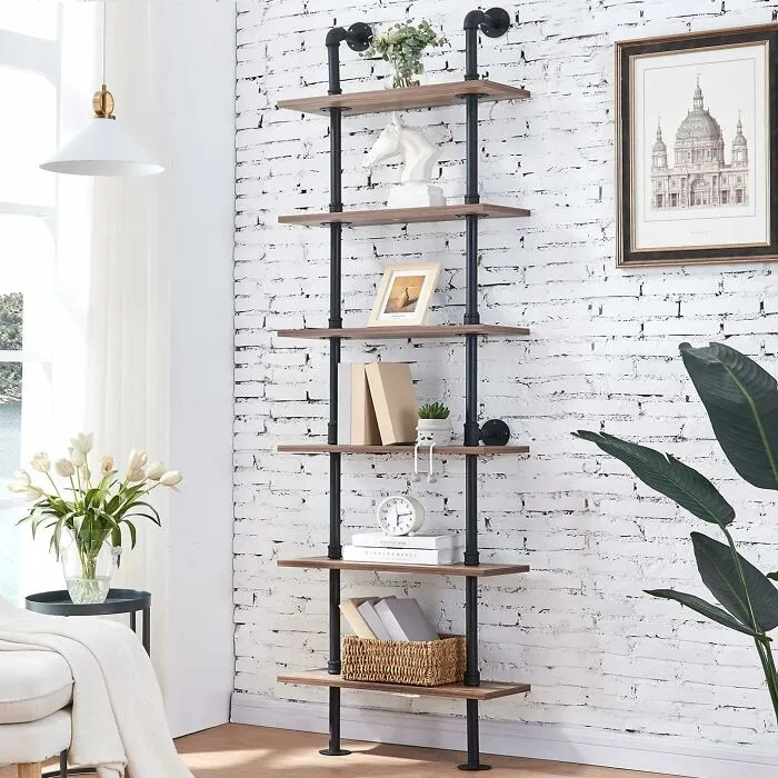 Vertical shelving unit against white brick wall, showcasing smart furniture solution for small living spaces.