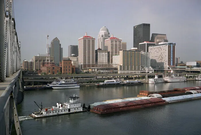 Skyline view of a city with boats on a river, showcasing amazing views of urban architecture against a clear sky.