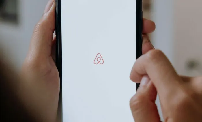 Person using Airbnb app on smartphone.