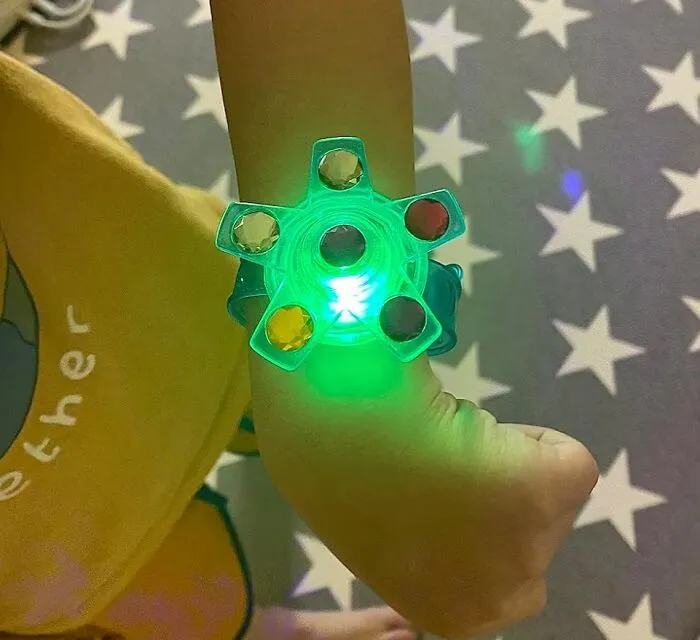 Child's arm wearing a glowing multicolored light-up bracelet, a perfect Valentine's Day gift kids love.