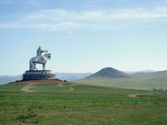 Massive silver statue of a horse and rider in a vast grassy plain, illustrating the concept of megalophobia and large scale.