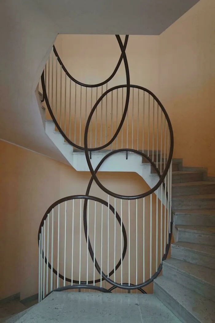 Modern staircase with creative circular metal railings, showcasing smart and cool designer innovation in architectural design.