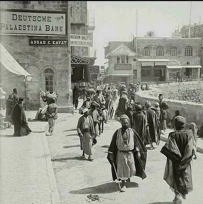 Esta fotografía, tomada hace más de 100 años en Jerusalén (1920), muestra un cartel al fondo en el que se lee « Banco Alemán de Palestina». Una notable ventana a la historia y a la vibrante presencia multicultural de la región en aquella época.
