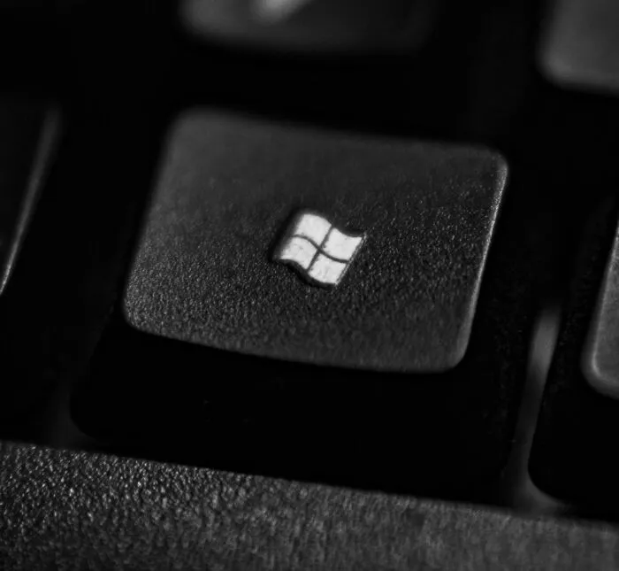 Close-up of a Windows key on a black keyboard, related to jokes about office work.