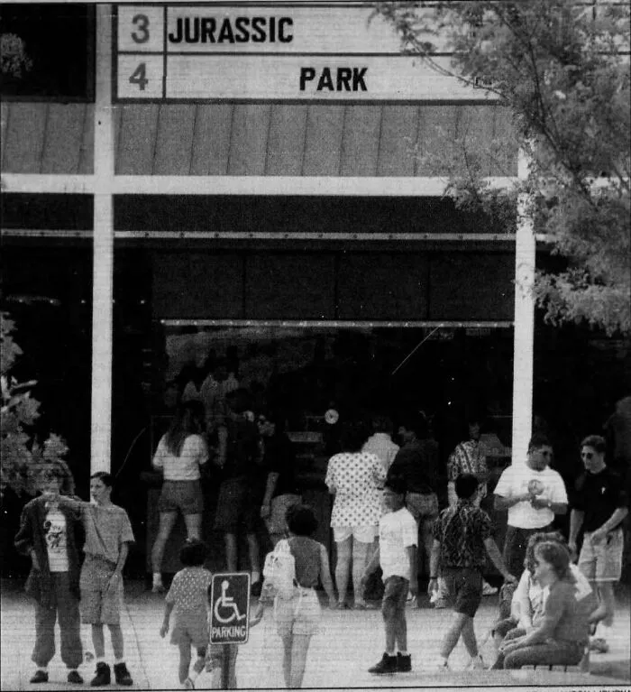 Crowd outside a theater showing "Jurassic Park," capturing a '90s vibe.
