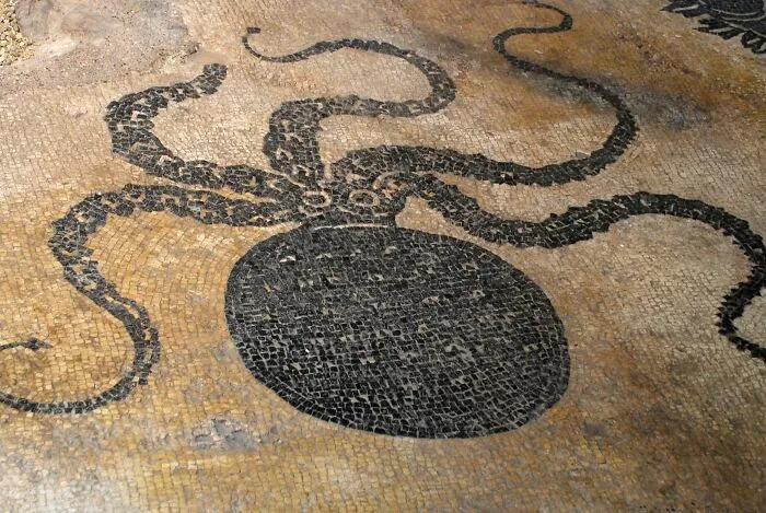 Ancient artefact featuring a mosaic of an octopus, well-preserved on a stone surface.
