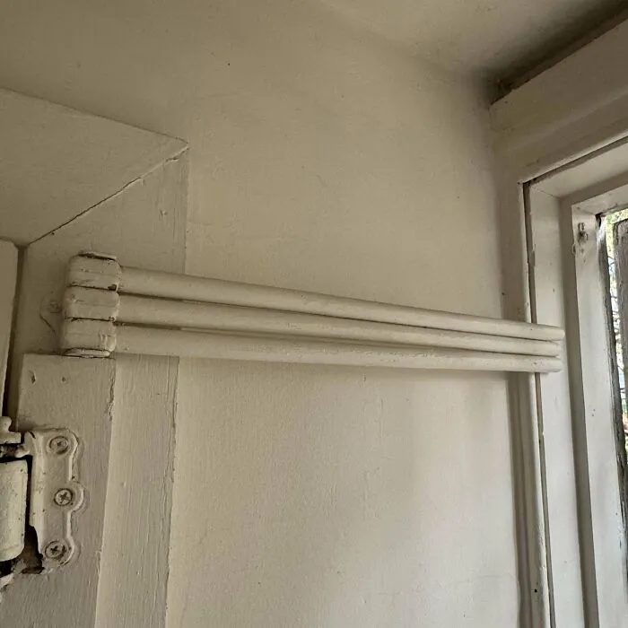 Just Moved Into A New Apartment, Didn’t Notice This On First Walk Though. What Is It? (Three Wooden Sticks Painted White, On Hinge That Lets Them Swing, By Backdoor)