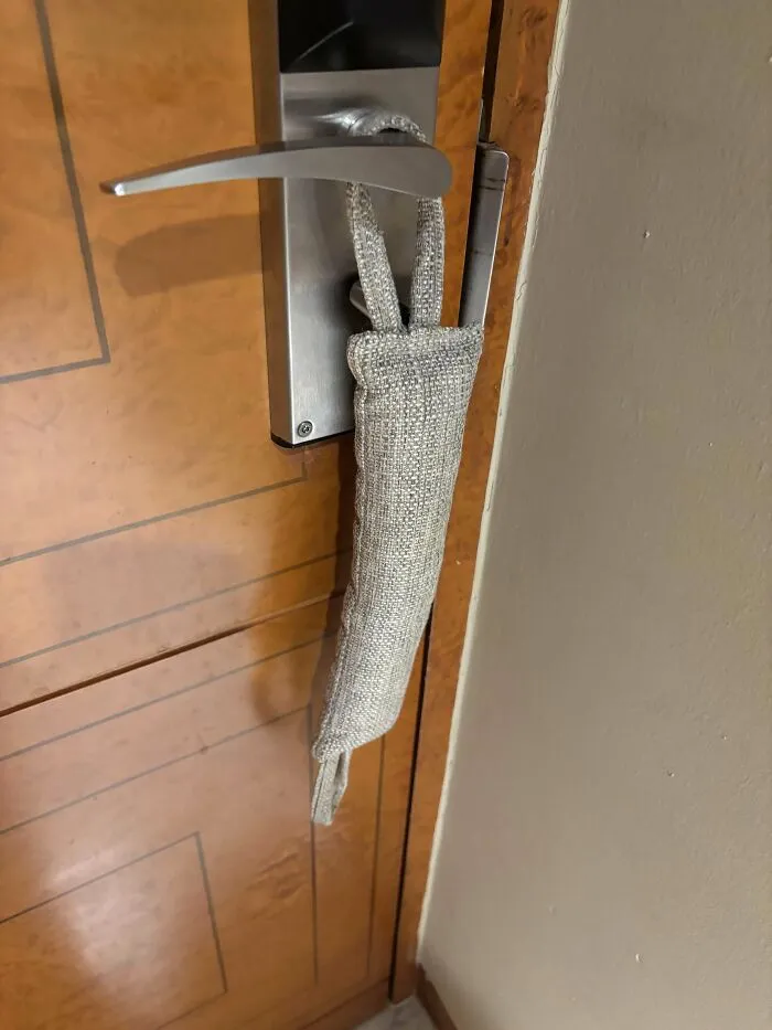 Foot And A Half Long Fabric Cushion Hanging From Interior Hotel Door Knob