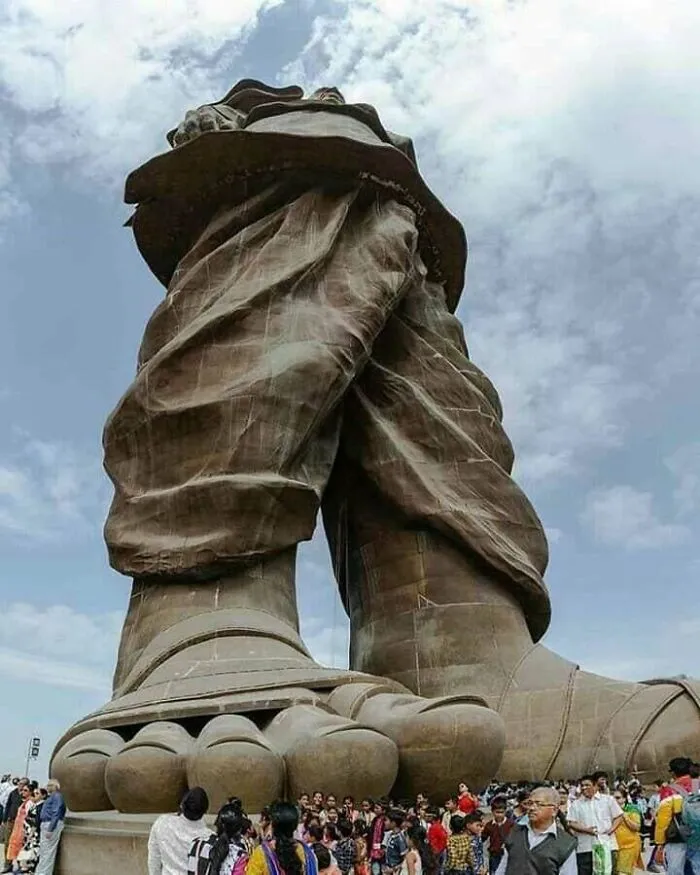 Massive statue with enormous feet towering over a crowd illustrating a megaphobia fear of giant objects.