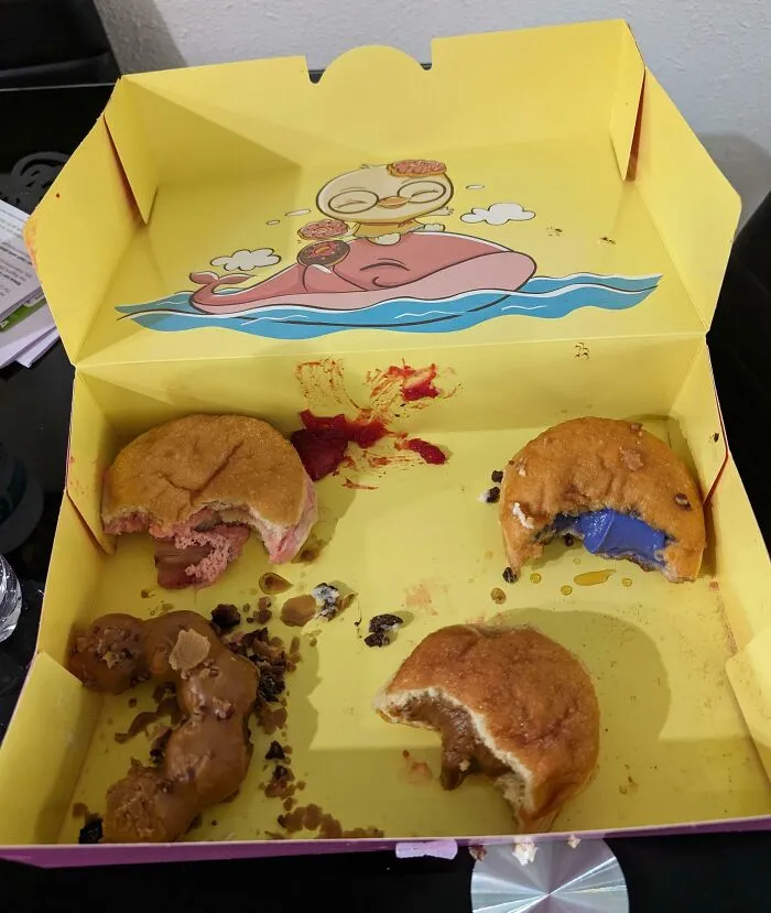 Caja amarilla de donas medio comidas, ejemplo divertido de novios y maridos comportándose como "hombres".