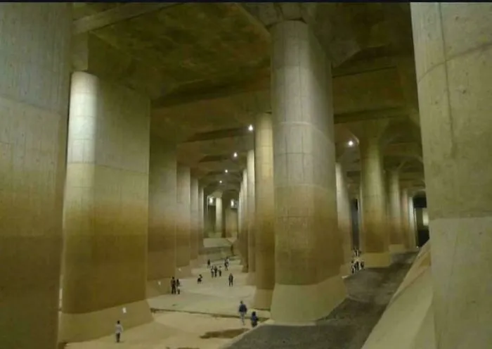 Massive concrete pillars underground with tiny people walking, illustrating megalophobia and the fear of scarily big structures.