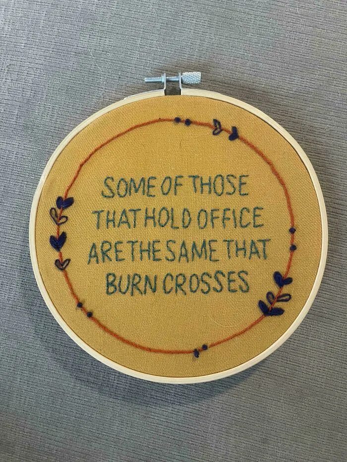 Embroidery hoop displaying a stitched quote surrounded by decorative leaves, showcasing beautiful embroidery skills.