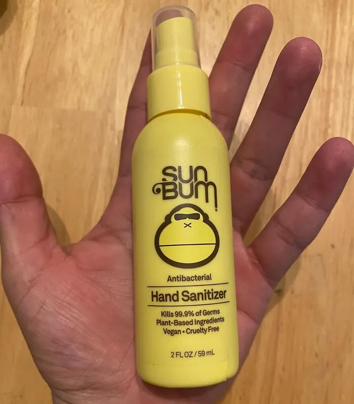 Hand holding Sun Bum antibacterial hand sanitizer, product to simplify daily life.