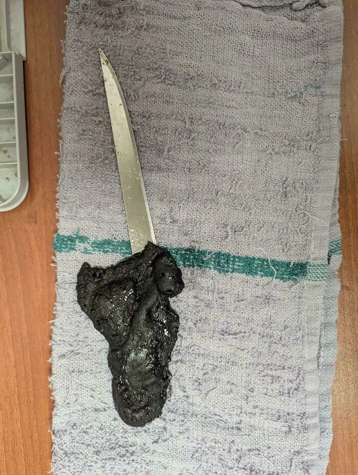 Burnt food on a metal skewer, resting on a gray cloth, highlighting issues faced in the food service industry.