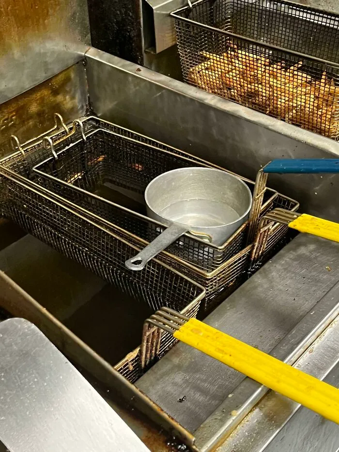 Deep fryer in a food service kitchen with fryer baskets, oil, and utensils, showcasing the food service industry.