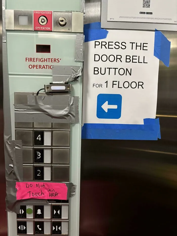 Elevator panel with duct tape repairs and handwritten signs demonstrating redneck engineer creativity and practical fixes.
