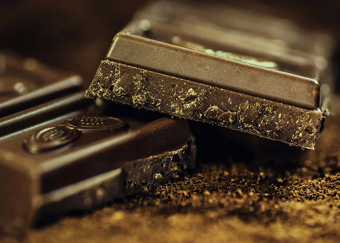 Close-up of two pieces of dark chocolate, showcasing texture and detail.