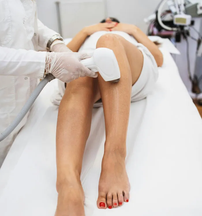 Person receiving a laser treatment on legs, highlighting rich people's detachment from reality.