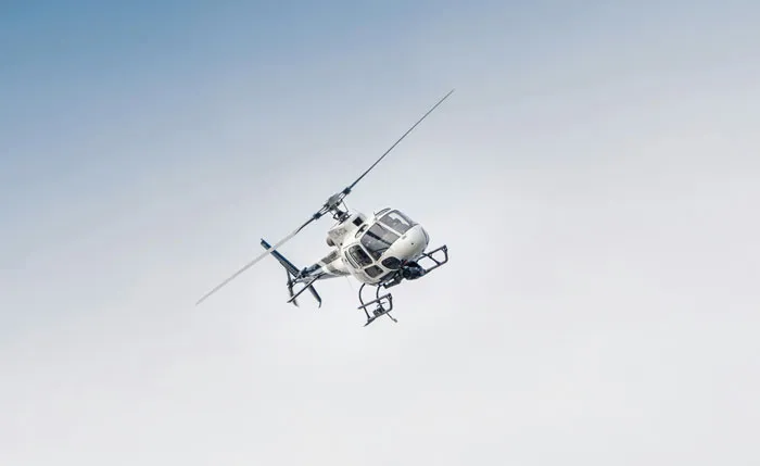 A helicopter soaring through the clear sky, symbolizing the luxury lifestyle of rich people.