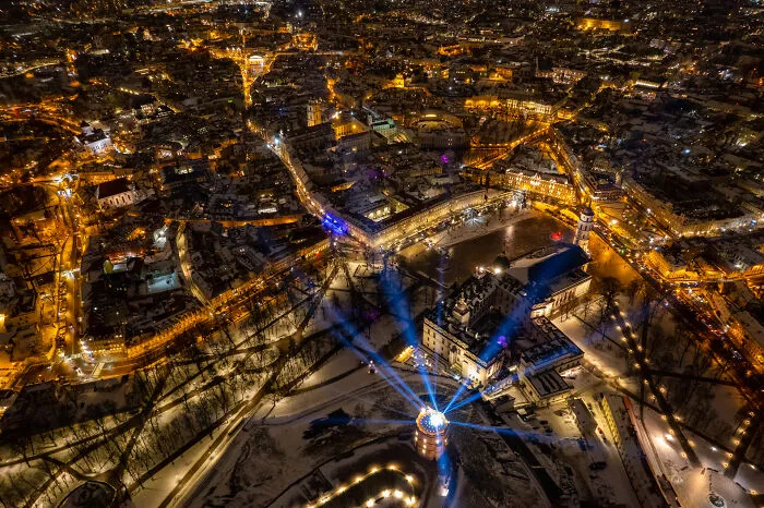 Lithuania cityscape at night captured from a bird's-eye view with illuminated streets and historic buildings.