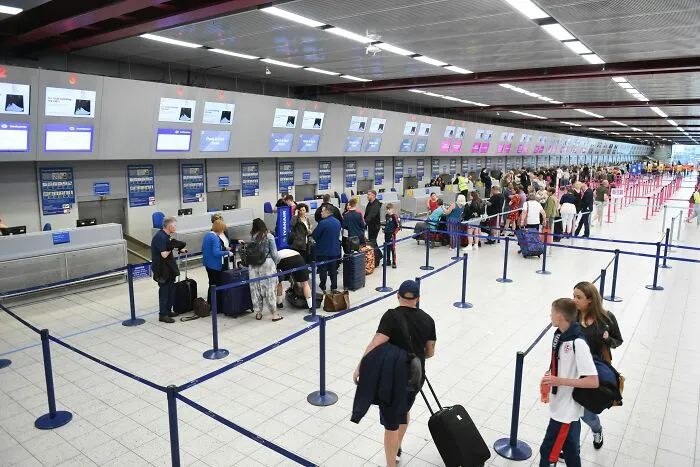 Crowded airport check-in area with long lines, illustrating stressful experiences often underestimated.