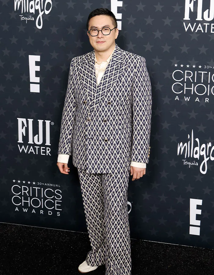 Person in a patterned suit at the Critics Choice Awards red carpet, posing for photos.