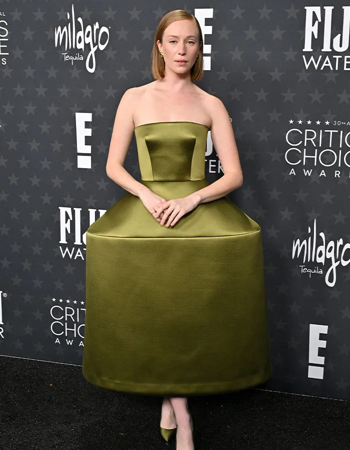 Person in a unique olive green dress at Critics Choice Awards red carpet, exemplifying daring outfits theme.