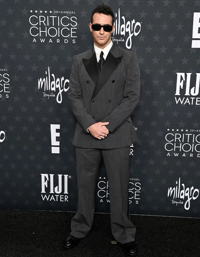 Man in a pinstripe suit and sunglasses at the Critics Choice Awards red carpet.