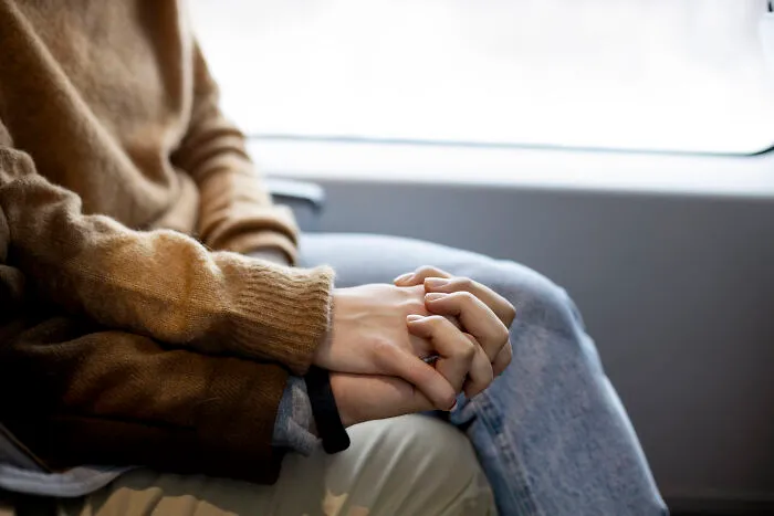 Hands gently clasped, symbolizing actions expressing love and care.