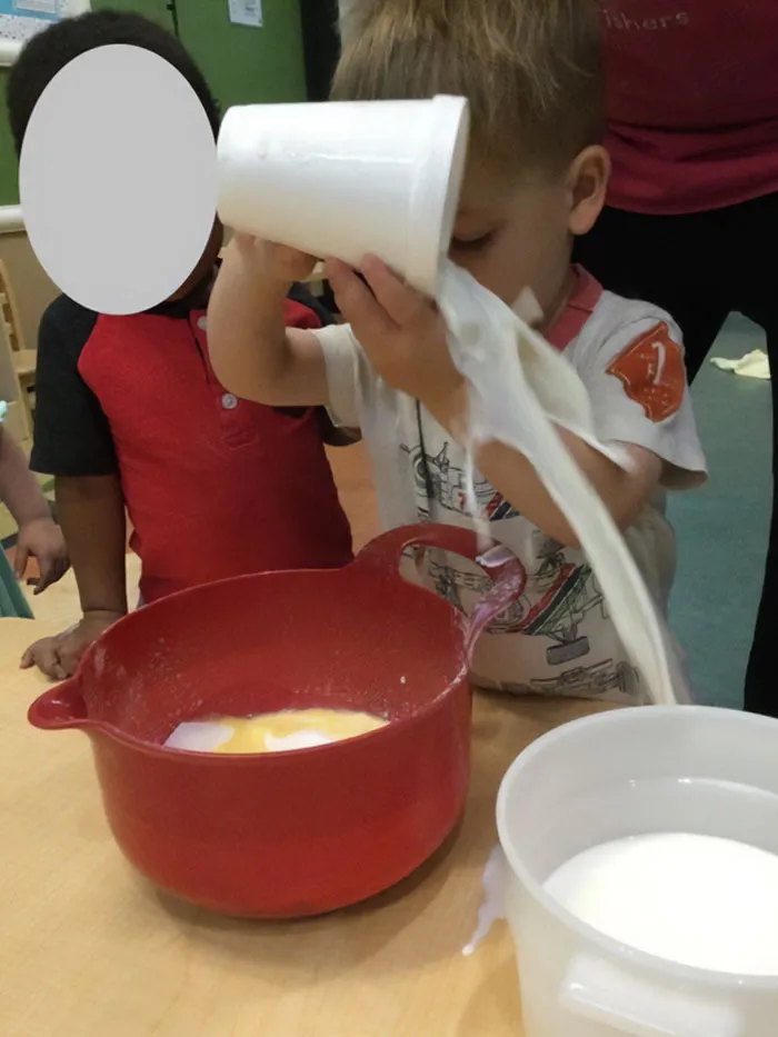 La foto que nos envió la guardería de mi hijo ayudándoles a hacer una tarta