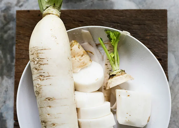 Sliced and whole daikon radish on a plate, a food people often start loving as they grow up.