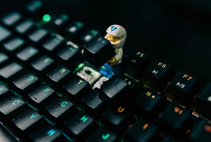 A toy figurine on a keyboard, humorously replacing a key, illustrating funny email sign-offs.