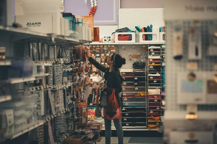Person shopping in a store aisle, browsing products that could improve their life.