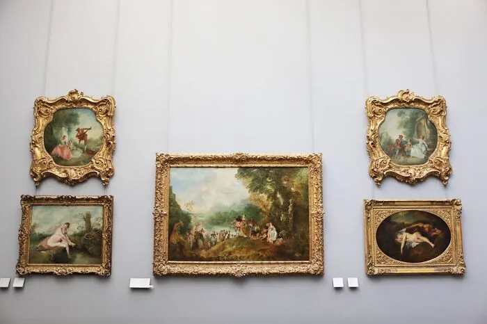Golden-framed paintings on a gallery wall, illustrating financial decisions through art.