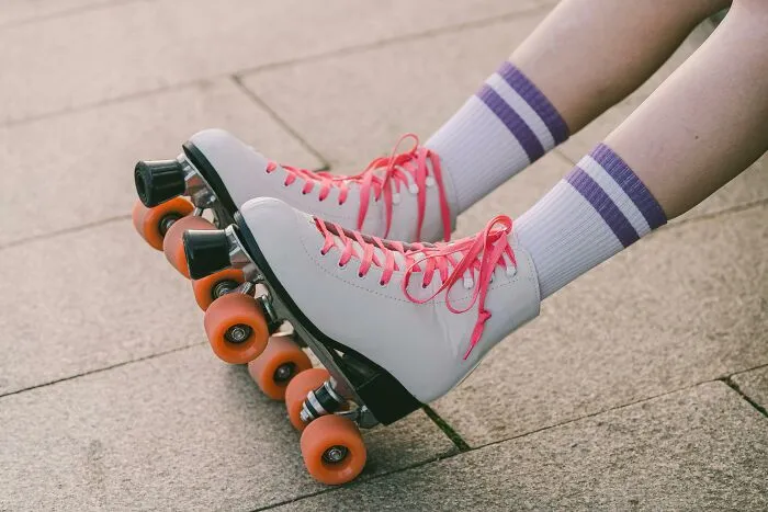 Roller skates with pink laces on a sidewalk, evoking hilarious conversations during a fun day out.