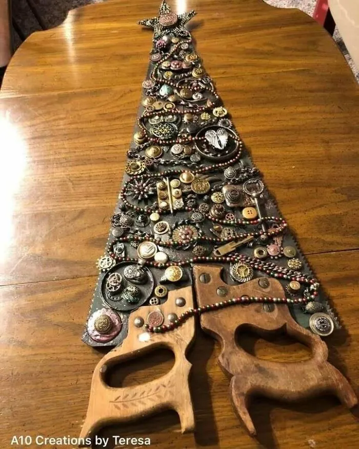 Recycled Christmas tree art made with vintage buttons and handles on a wooden table.