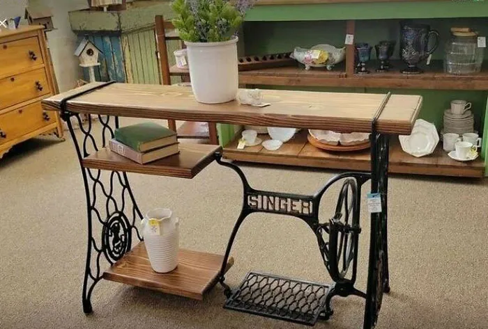 Repurposed sewing machine table with wooden shelves inspires recycling in home decor.