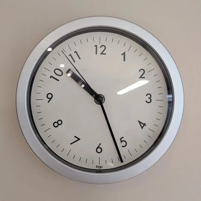 Clock showing unusual time with eleven-hour hand paired with five-minute hand.
