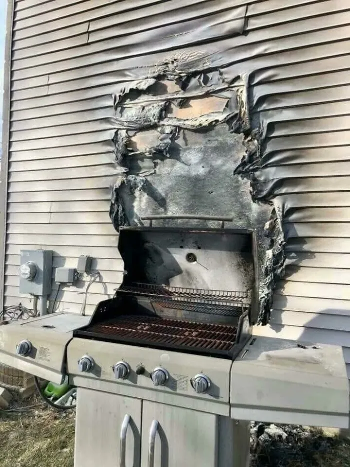 Melted siding and damaged wall from a grill accident, illustrating a super expensive incident.