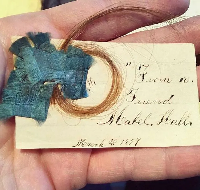 Unique bookmark with lock of hair and handwritten note from 1878, shared by a book lover.