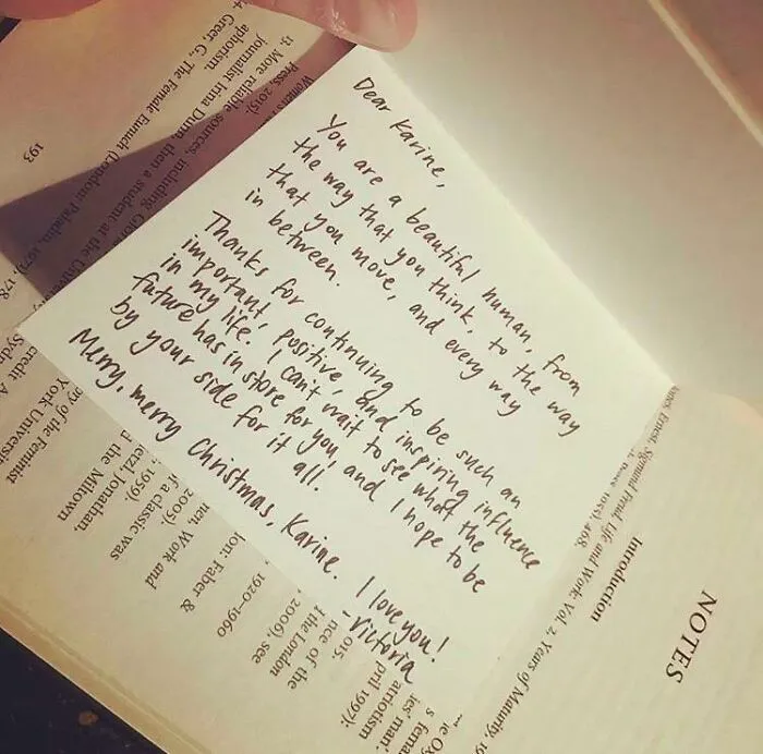 Handwritten note bookmark in a book with a heartfelt message, shared by book lovers.