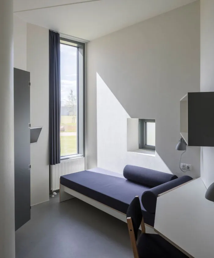 Habitación minimalista con cama y escritorio, mostrando detalles ingeniosos en diseño cotidiano.