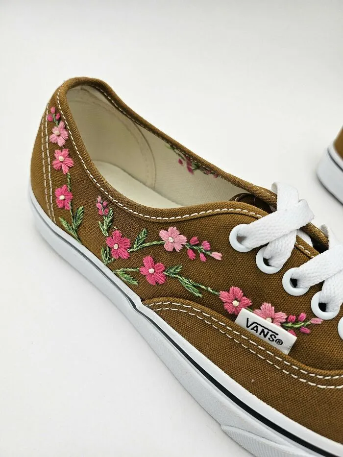 Brown Vans shoe with floral embroidery as a DIY project, showcasing intricate pink flowers and green leaves.