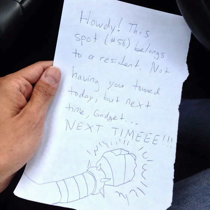 Hand holding a passive-aggressive note about parking, referencing “Gadget” and warning about towing next time.