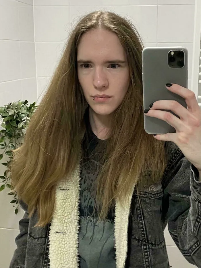 Person with fierceflow beautiful hair taking a mirror selfie in a bathroom wearing a denim jacket with fleece lining.