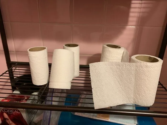 Rollos de papel higiénico vacíos en estante; problemas con la familia política.